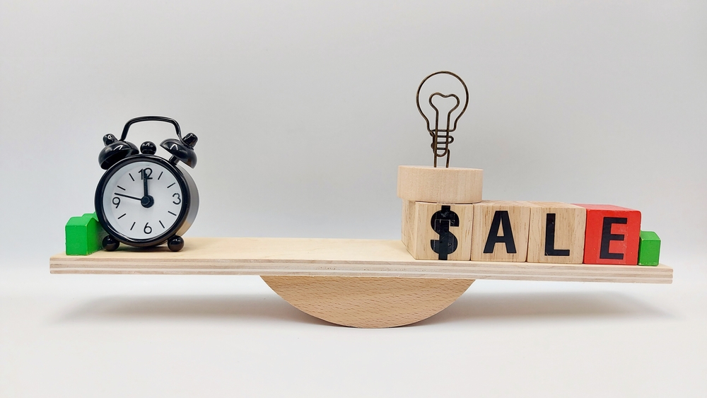 A Clock and wooden blocks making the word sale